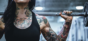 Vegan strength training lady holding barbell