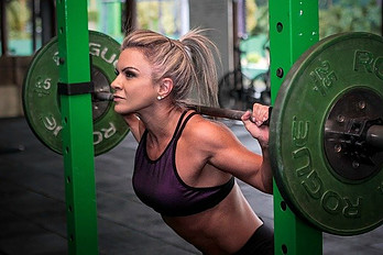 Woman performing a compound exercise - barbell squat